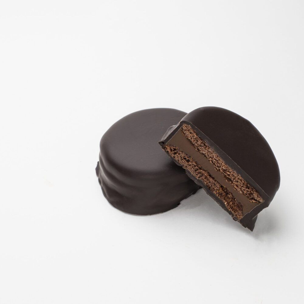 Foto de un alfajor marplatense de dulce de leche_negro, partido a la mitad para mostrar el relleno - Argenpastry SL